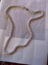 Two necklaces, one cross necklace, and one pearl necklace