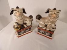 PAIR OF ORIENTAL STYLE DOG BOOKENDS. ONE IS MISSING AN EAR. MARKED "UNDER STRICT SUPERVISION BY