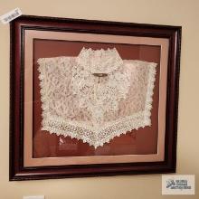 Picture made of lace collar with ornate pin