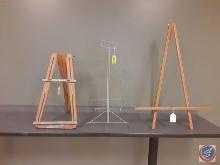 (2) wooden easels, and one metal easel