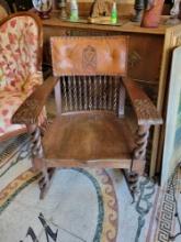 Antique oak rocking chair with ornate spindle frame and leather padded back